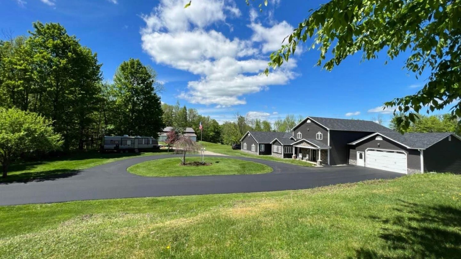 Circular asphalt driveway around a lawn island at a Vermont home
