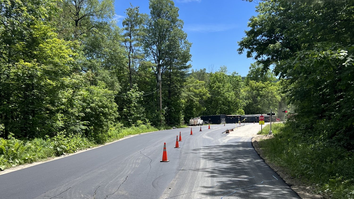 Fresh asphalt on a wooded Vermont road with cones