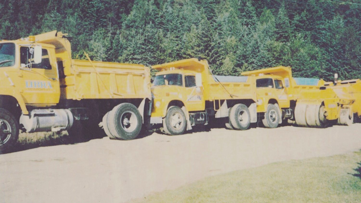Archive photo of the yellow dump truck and roller fleet lined up
